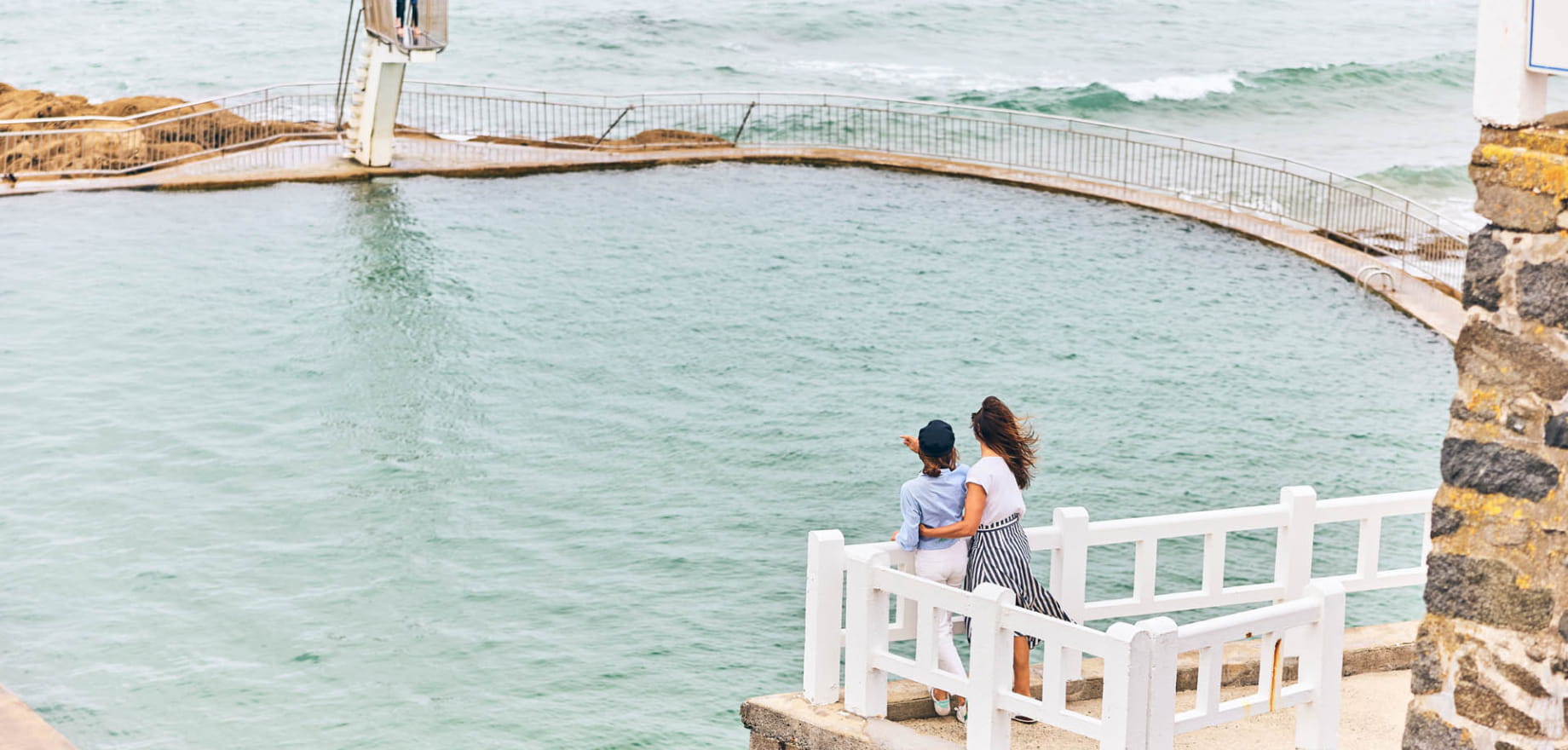 Une mère et sa fille contemplent la piscine d'eau de mer